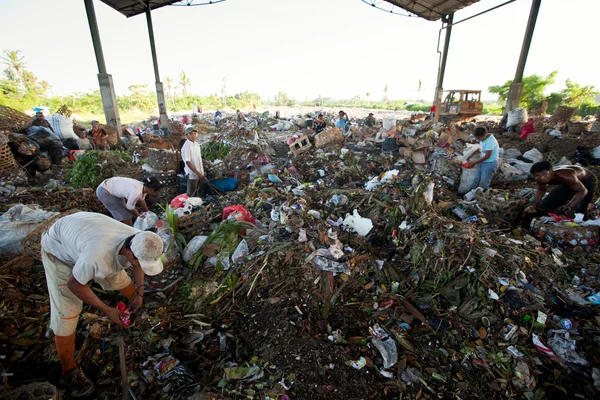 BALI, INDONESIA 11 DE ABRIL: Pobres de la isla de Java que trabajan en un desguace en el vertedero el 11 de abril de 2012 en Bali, Indonesia. Bali produce diariamente 10.000 metros cúbicos de residuos . —  Fotos de Stock